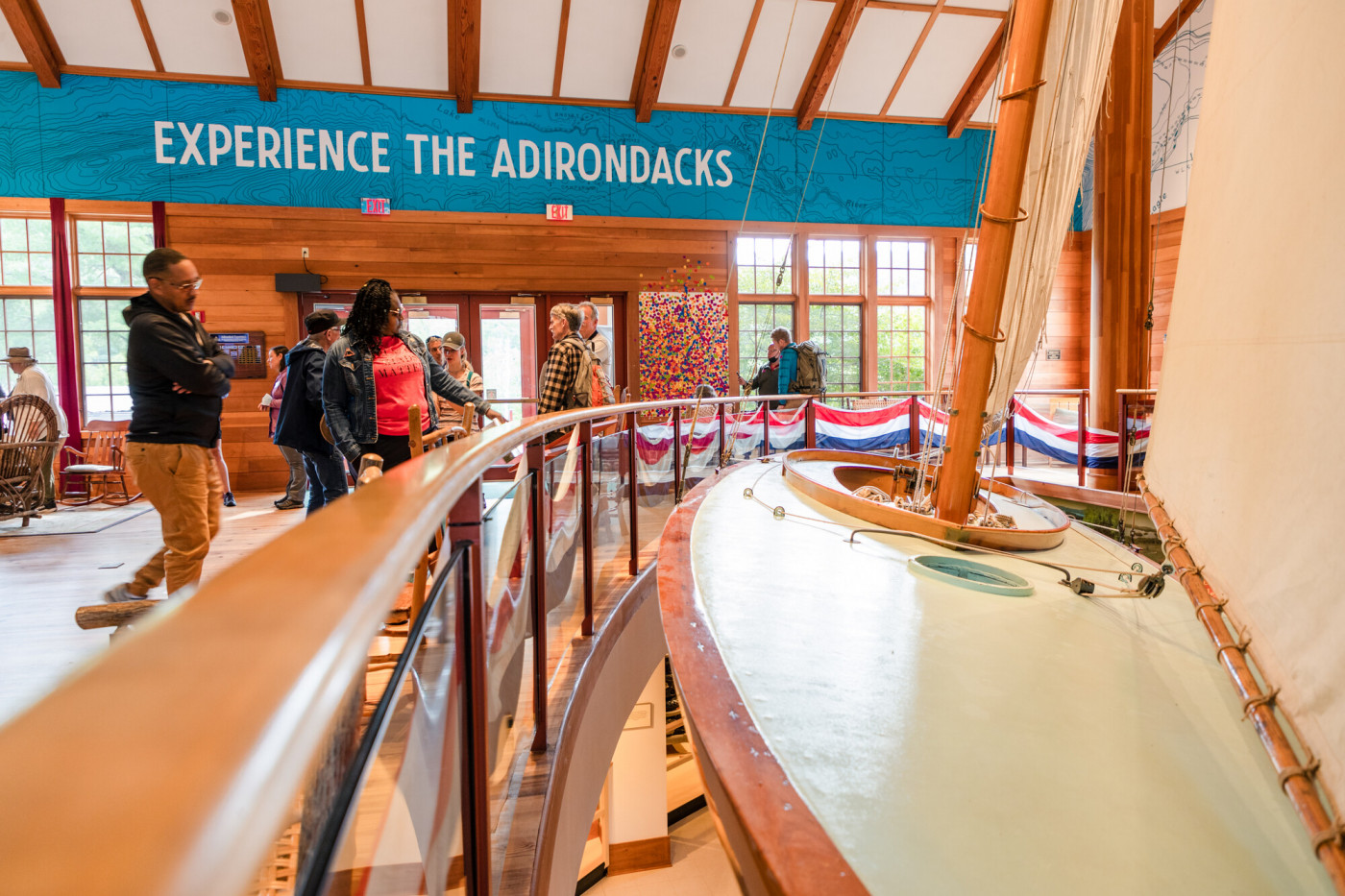 A group of visitors next to a sailboat in an interior museum exhibit.